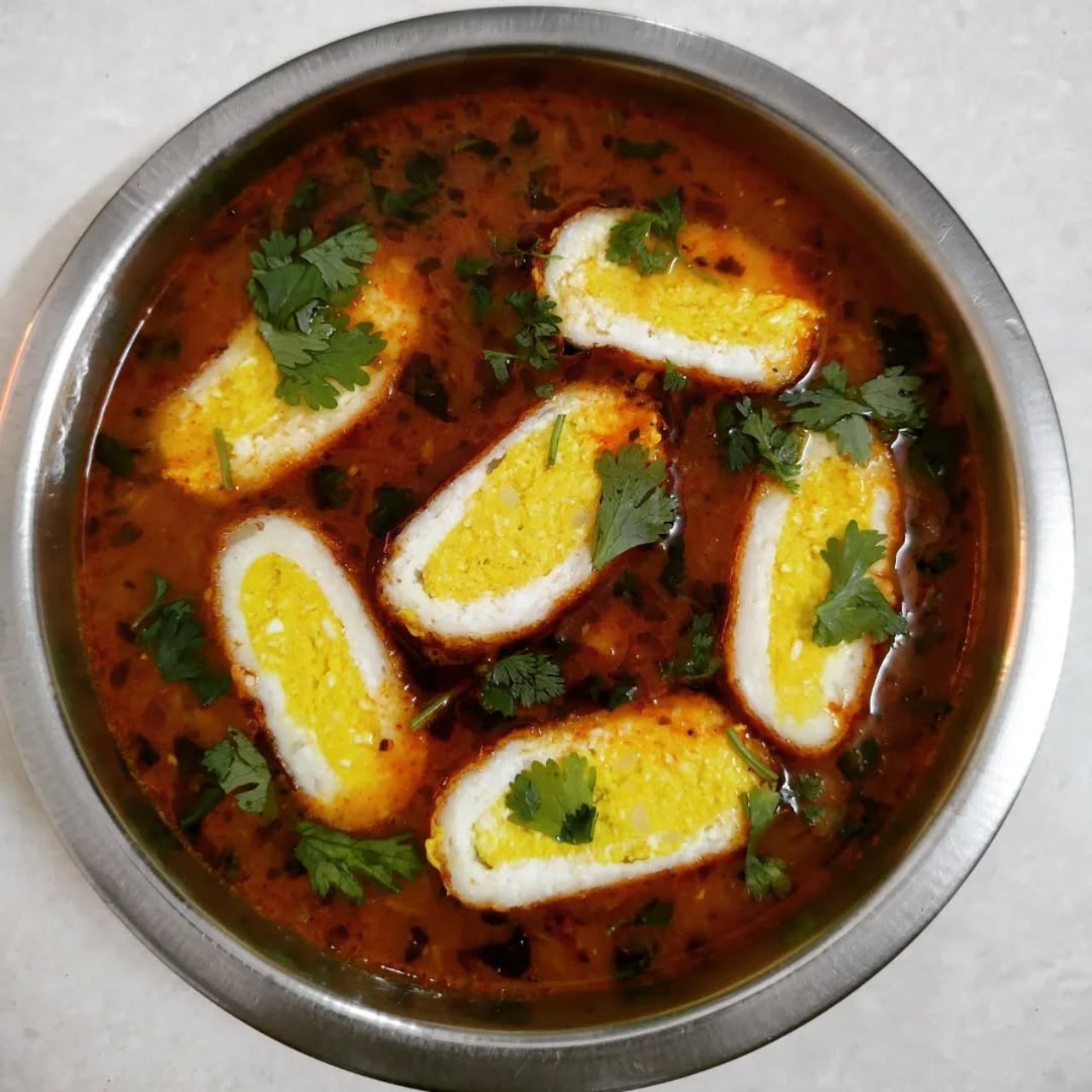 अब करी बनाने के लिए एक कढ़ाही में तेल गरम करें.  इसमें प्याज डालकर सुनहरा होने तक भूनें. फिर अदरक-लहसुन पेस्ट और हरी मिर्च डालें. खुशबू आने तक भूनें. अब टमाटर का पेस्ट डालें और मसाले (हल्दी, धनिया, लाल मिर्च) मिलाकर अच्छी तरह भूनें जब तक तेल न छोड़ने लगे. अब नमक और थोड़ा पानी डालें.